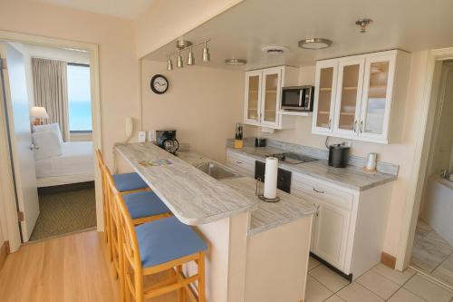 a kitchen with a counter and a kitchen island with chairs at Four Sails Resort in Virginia Beach