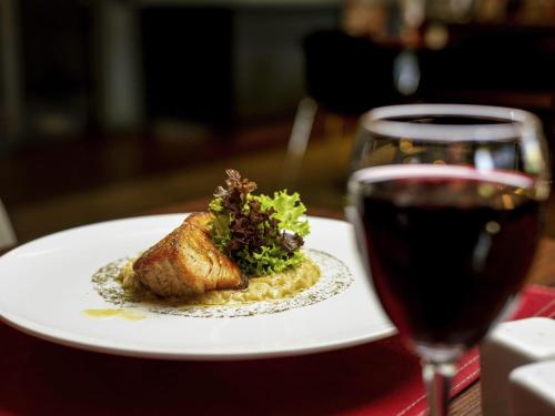 a plate of food next to a glass of wine at ibis Santiago Estacion Central in Santiago