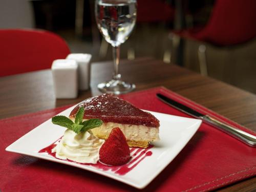 a piece of cake and a strawberry on a plate on a table at ibis Santiago Estacion Central in Santiago