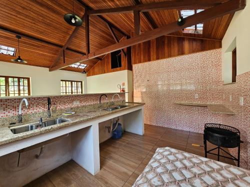 a large kitchen with sinks and a wooden ceiling at Casa Incrível em Nova Friburgo - Espaço Humedica in Nova Friburgo