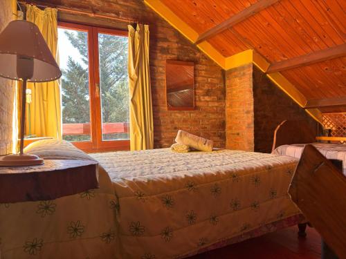 a bedroom with two beds and a window at Ecoparque Kooch in Sierra de la Ventana