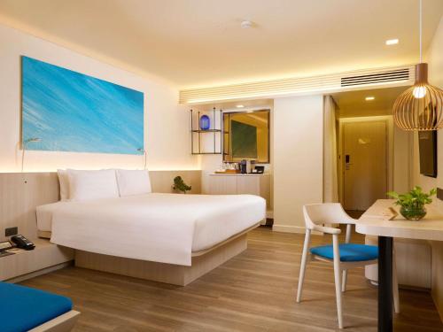a hotel room with a bed and a desk at Pullman Pattaya Hotel G in Pattaya North