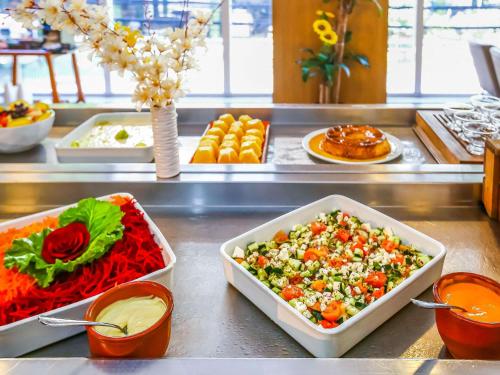 a buffet with salads and other food on a counter at ibis Rio de Janeiro Botafogo in Rio de Janeiro