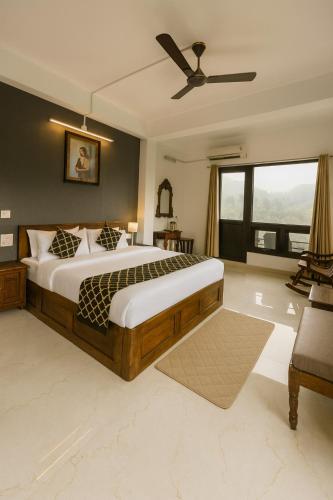a bedroom with a large bed and a ceiling fan at The Mayur Captain Grand Resort kasauli in Kasauli