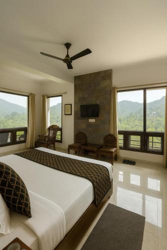 a bedroom with a large bed with a ceiling fan at The Mayur Captain Grand Resort kasauli in Kasauli