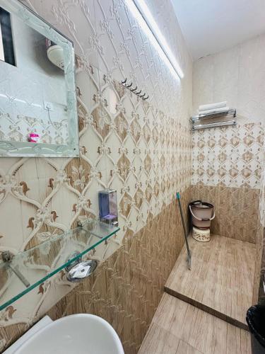 a bathroom with a glass shelf and a toilet at The Mayur Captain Grand Resort kasauli in Kasauli