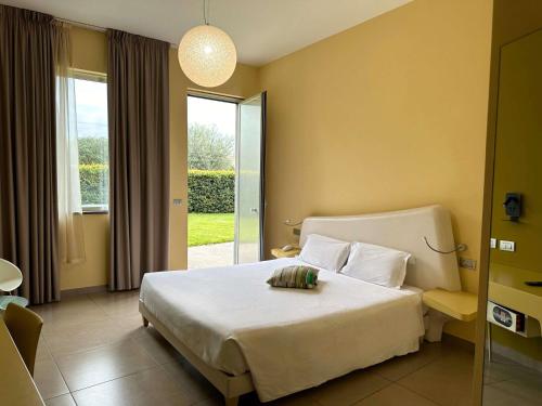 a hotel room with a bed and a large window at ibis Styles Catania Acireale in Acireale