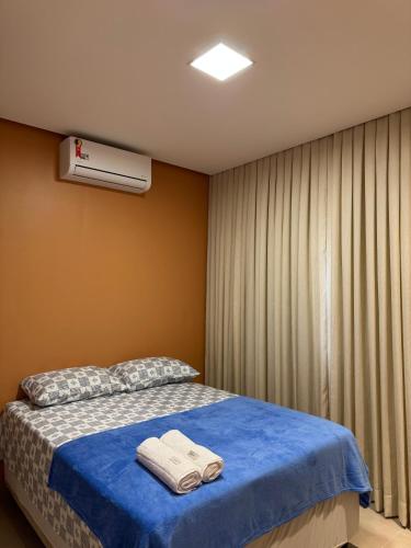 a bedroom with a bed with two towels on it at Ilha Bela Alter do chão - Apartment 2 suites in Santarém
