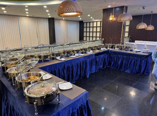 a banquet hall with blue tables with plates of food at Al Shaiki Hotel in Al Jubail