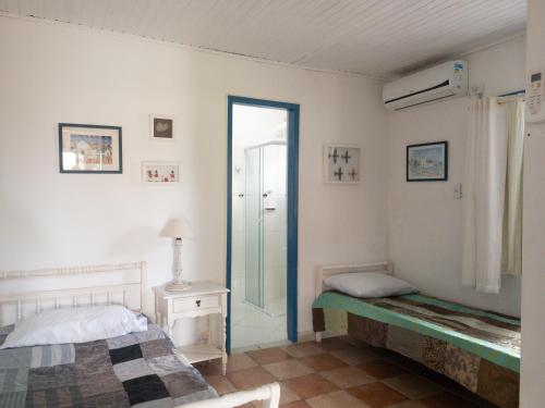 una camera con un letto e una porta con una finestra di FLORIPA PÉ na AREIA a Florianópolis