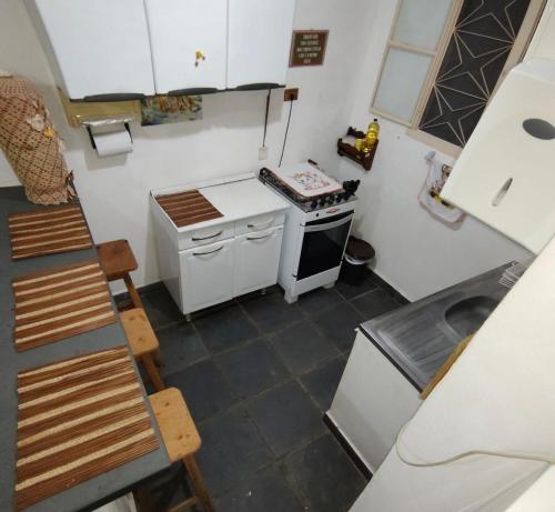 a small kitchen with a stove and a sink at Casa em frente a praça principal in Rio das Flores
