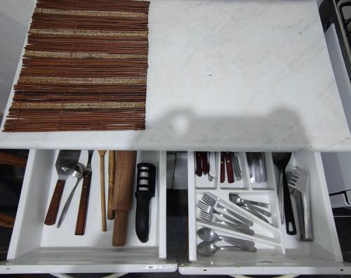a drawer filled with lots of utensils at Casa em frente a praça principal in Rio das Flores