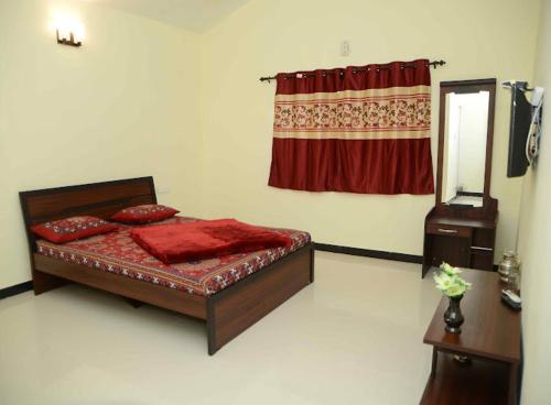 a bedroom with a bed and a mirror and a window at Misty Homes in Madikeri