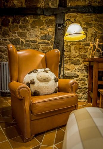 a stuffed teddy bear sitting in a leather chair at Casa de piedra en el corazón de Potes in Potes