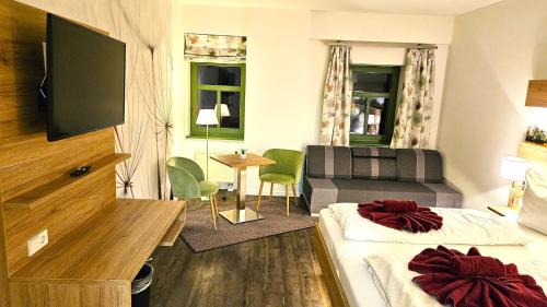 a hotel room with a bed and a couch at Gutshof Hauber in Dresden