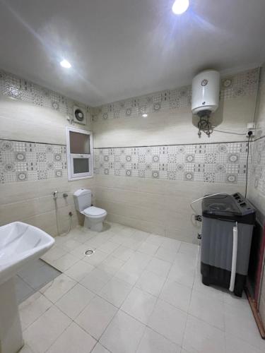 a bathroom with a toilet and a sink at شقة ذات موقع رائع in An Nikāshah