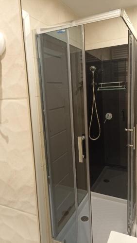 a shower with a glass door in a bathroom at Apartament Pod Lipami in Hajnówka