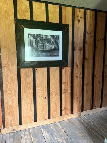a picture on the wall of a room with wooden walls at El ático in Barra de Portezuelo