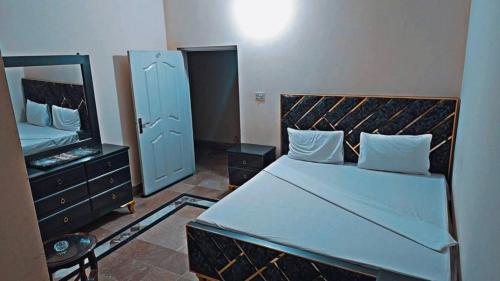 Un dormitorio con una cama grande y un espejo. en Royal Inn Guest House, en Harīpur