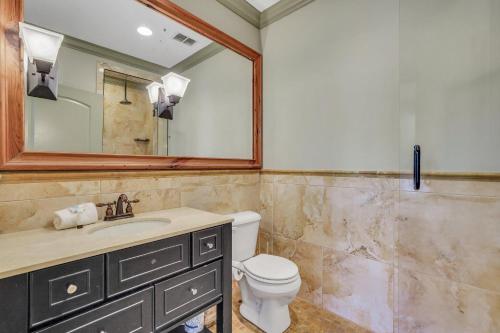 a bathroom with a toilet and a sink and a mirror at McDonough's Inn Unit 1 by Lucky Savannah in Savannah