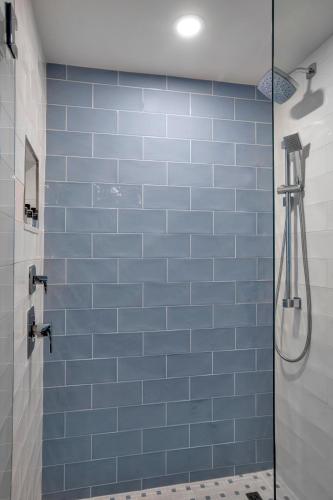 a bathroom with a blue tiled wall and a shower at Jupiter Beach Resort & Spa in Jupiter