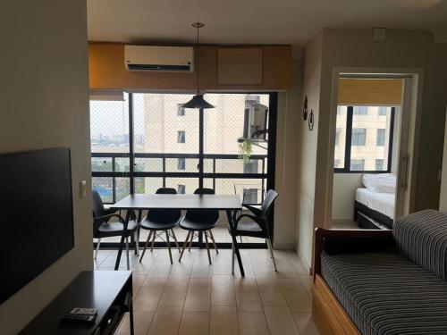 a living room with a table and chairs and a bedroom at Airfamily Congonhas in Sao Paulo