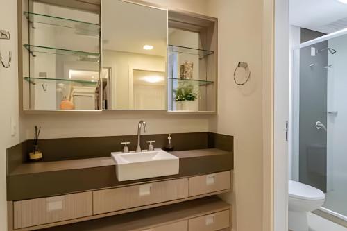 ボンビーニャスにあるCobertura com jacuzzi 2 minutos da praiaの洗面台と鏡のあるバスルーム