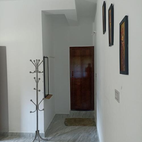a room with a hallway with a door and some pictures at Misty Homes in Madikeri