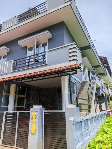 a blue house with a yellow statue in front of it at Misty Homes in Madikeri