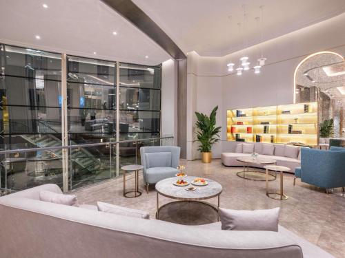 a lobby with a couch and chairs and a table at Mercure Beijing Downtown in Beijing