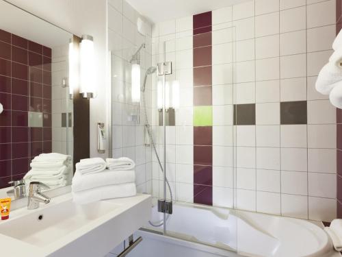 ein weißes Badezimmer mit Waschbecken und Dusche in der Unterkunft ibis Styles Beaune Centre in Beaune