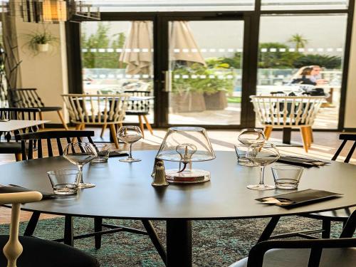 a table with wine glasses on it in a restaurant at Novotel Avignon Centre in Avignon