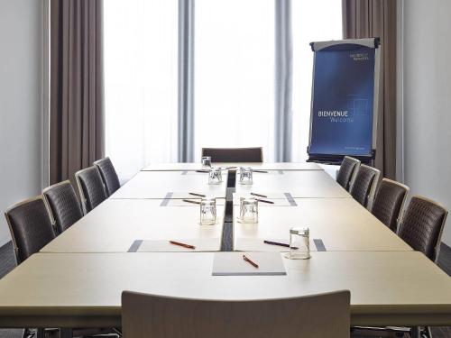 a conference room with a large table and chairs at Novotel Avignon Centre in Avignon
