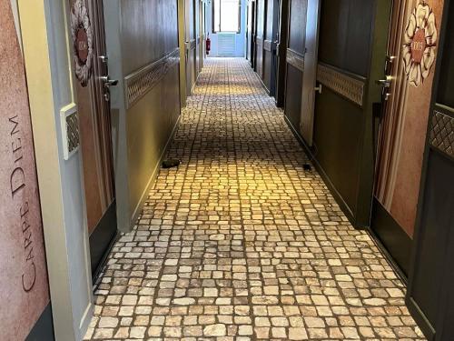 un couloir avec un sol carrelé dans un immeuble dans l'établissement ibis Styles Nimes Gare Centre, à Nîmes