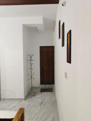 a room with a white wall with a wooden door at Misty Homes in Madikeri