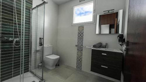 Un baño con inodoro, lavabo y ducha. en Los Ajaches - Caracolas, en Mácher