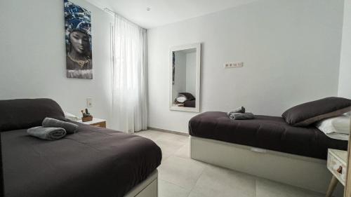 Un dormitorio con dos camas y un espejo. en Los Ajaches - Caracolas, en Mácher
