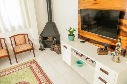 a living room with a tv and a fireplace at Pousada Casa do Reiki in Rancho Queimado