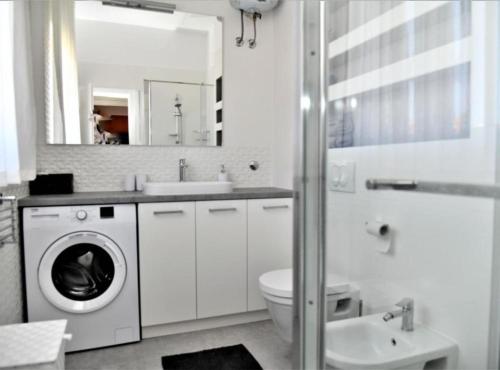 a white bathroom with a washing machine and a sink at Apartments Near Sea Supetar in Supetar
