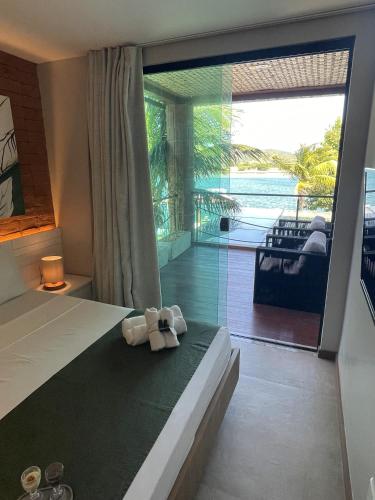 a bedroom with a bed with a view of the ocean at Bravo Pousada Design in Cabo Frio