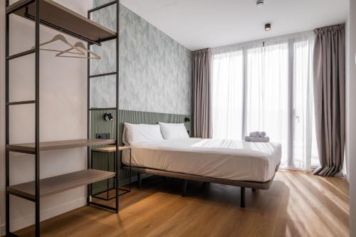 a bedroom with a bed and a book shelf at Pensión SÖMN Donostia in Donostia-San Sebastián