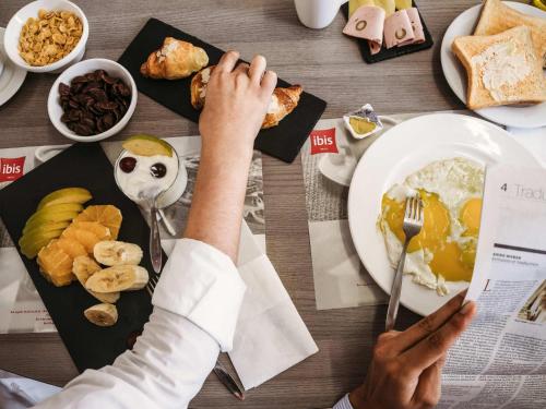 a person eating food at a table with a plate of food at Ibis Casanearshore in Casablanca