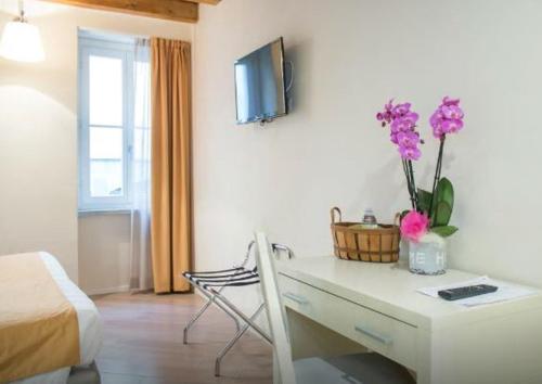 a room with a desk with purple flowers on it at La Corte Fiorita Como in Como