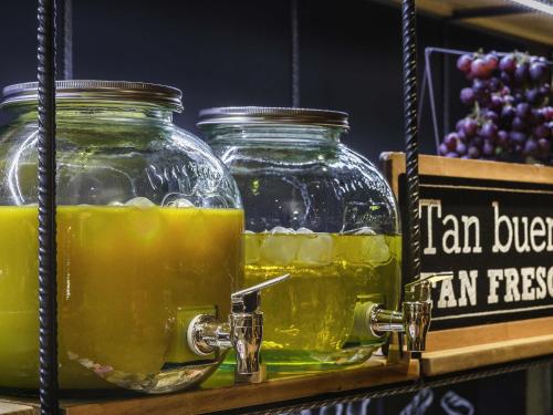 two glass jars of orange juice on a shelf at Ibis Lleida in Lleida