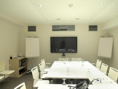 a conference room with a large white table and chairs at Ibis Lleida in Lleida