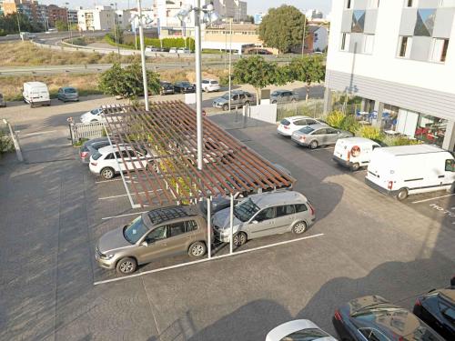 a parking lot with cars parked in a parking lot at Ibis Lleida in Lleida