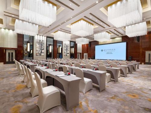 a large room with tables and chairs and a projection screen at Pullman Shanghai Jing'an-Jing'an district, downtown railway station, traffic hub, easy to travel Shanghai in Shanghai