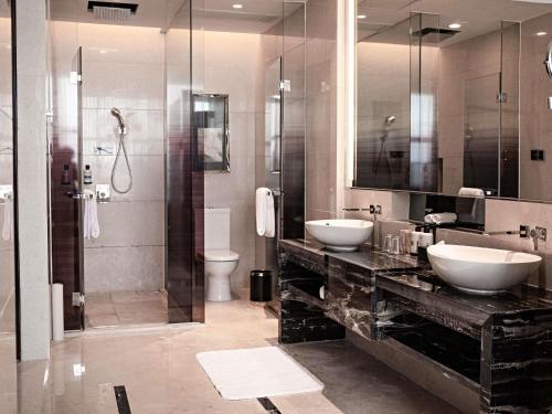 a bathroom with two sinks and a shower at Pullman Shanghai Jing'an-Jing'an district, downtown railway station, traffic hub, easy to travel Shanghai in Shanghai