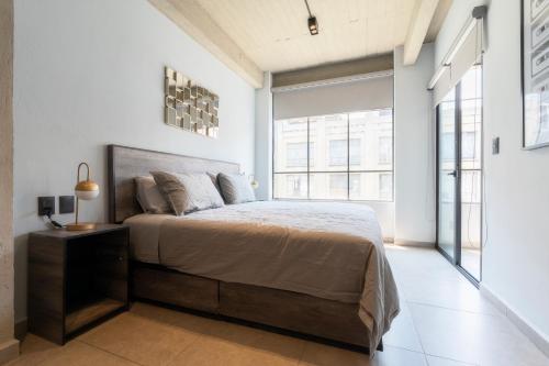 a bedroom with a bed and a large window at Zielo 3bdrm 2 bath Private balcony, Rooftop Walk to Zocalo in Mexico City
