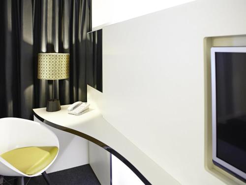 a living room with a white chair and a tv at Ibis Styles Liverpool Centre Dale Street - Cavern Quarter in Liverpool